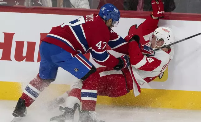 Montreal Canadiens' Jayden Struble (47) checks Detroit Red Wings' Jonatan Berggren (48) into the boards during the second period of an NHL hockey game in Montreal on Tuesday, April 8, 2025. (Christinne Muschi/The Canadian Press via AP)