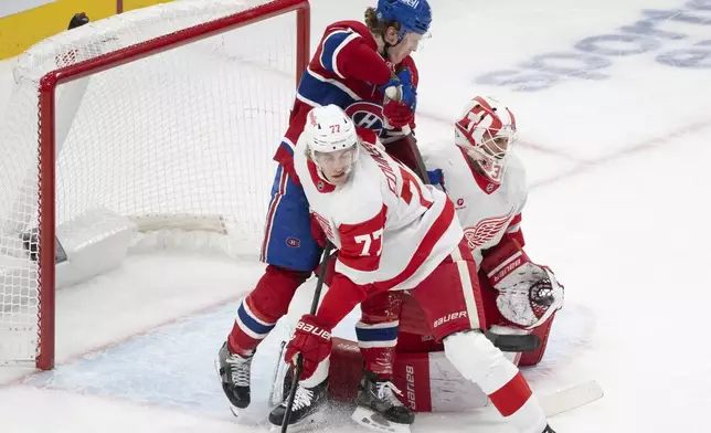 Detroit Red Wings goaltender Cam Talbot (39) makes a glove save as Montreal Canadiens' Christian Dvorak (28) looks for the rebound against Red Wings' Simon Edvinsson (77) during the first period of an NHL hockey game in Montreal on Tuesday, April 8, 2025. (Christinne Muschi/The Canadian Press via AP)