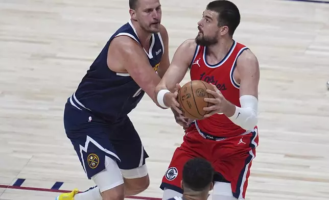 Los Angeles Clippers center Ivica Zubac, right, drives past Denver Nuggets center Nikola Jokic, left, in the first half of Game 2 of a first-round NBA playoff series Monday, April 21, 2025, in Denver. (AP Photo/David Zalubowski)