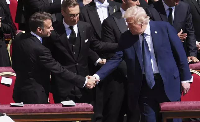 President Donald Trump, right, shakes hands with French President Emmanuel Macron, left, as Finland's President Alexander Stubb, looks on, as they attend the funeral of Pope Francis in St. Peter's Square at the Vatican, Saturday, April 26, 2025. (AP Photo/Evan Vucci)