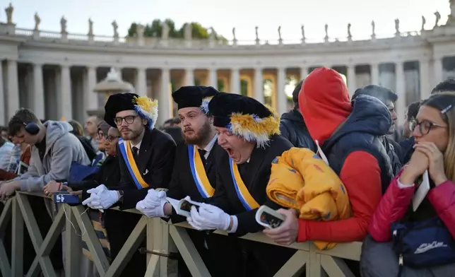 A man yawns as people arrive in St. Peter's Square ahead of the funeral of Pope Francis at the Vatican, Saturday, April 26, 2025. (AP Photo/Andreea Alexandru)