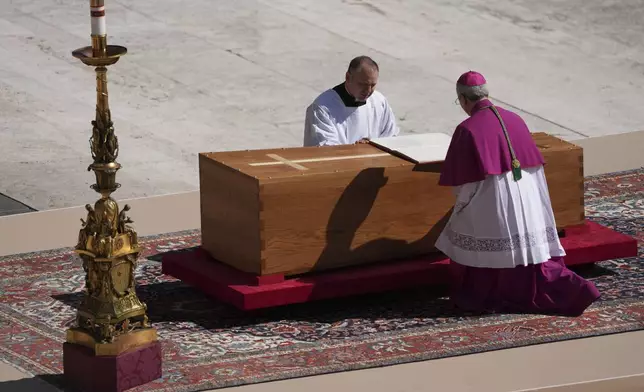 Archbishop Diego Giovanni Ravelli, kneeling right, presides over the funeral of Pope Francis in St. Peter's Square at the Vatican, Saturday, April 26, 2025. (AP Photo/Evan Vucci)