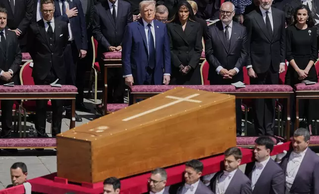 The coffin of Pope Francis is carried in front of dignitaries, including President Donald Trump, center, during his funeral in St. Peter's Square at the Vatican, Saturday, April 26, 2025. (AP Photo/Gregorio Borgia)