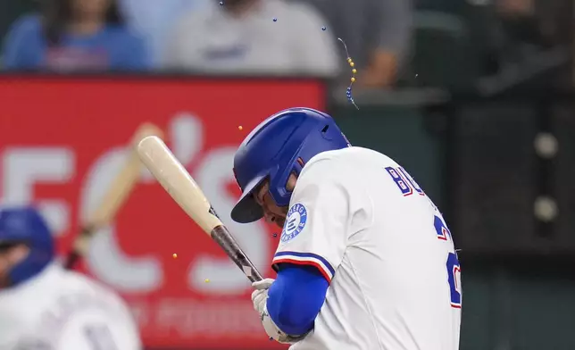 Jewelry breaks after Texas Rangers' Jake Burger was hit by a pitch from Los Angeles Angels starting pitcher Jack Kochanowicz during the second inning of a baseball game Thursday, April 17, 2025, in Arlington, Texas. (AP Photo/Julio Cortez)