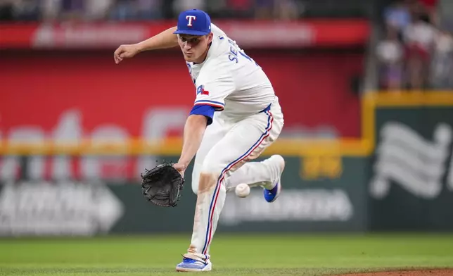 Texas Rangers shortstop Corey Seager fields an infield hit by Los Angeles Angels' Tim Anderson during the fifth inning of a baseball game Thursday, April 17, 2025, in Arlington, Texas. (AP Photo/Julio Cortez)