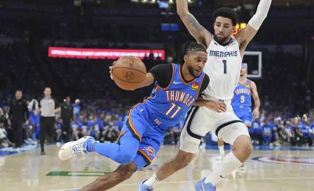 Oklahoma City Thunder guard Isaiah Joe (11) drives past Memphis Grizzlies guard Scotty Pippen Jr. (1) during the first half in Game 1 of an NBA first-round playoff series, Tuesday, April 22, 2025, in Oklahoma City. (AP Photo/Kyle Phillips)