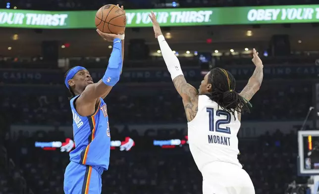 Oklahoma City Thunder guard Shai Gilgeous-Alexander, left, shoots over Memphis Grizzlies guard Ja Morant, right, during the first half in Game 1 of an NBA first-round playoff series, Tuesday, April 22, 2025, in Oklahoma City. (AP Photo/Kyle Phillips)