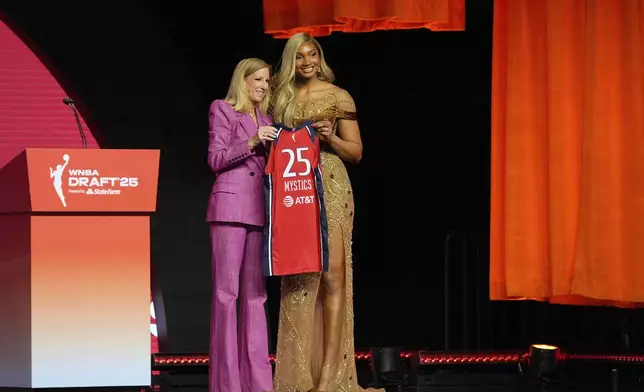 Southern California's Kiki Iriafen, right, poses with WNBA commissioner Cathy Engelbert after being selected fourth overall by the Washington Mystics during the first round of the WNBA basketball draft, Monday, April 14, 2025, in New York. (AP Photo/Pamela Smith)