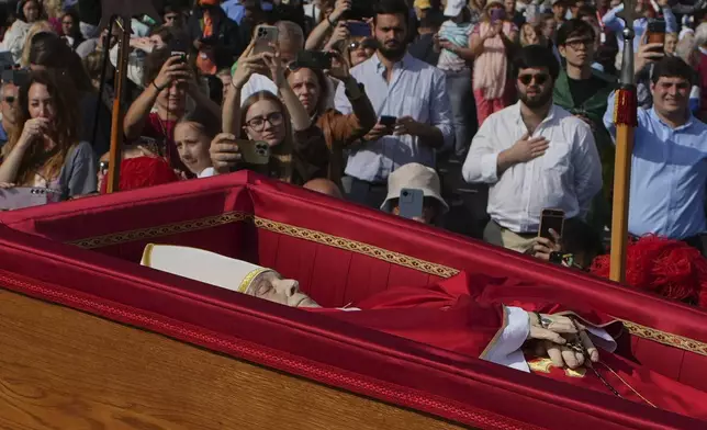 The body of Pope Francis is carried into St. Peter's Basilica at the Vatican, Wednesday, April 23, 2025, where he will lie in state for three days. (AP Photo/Emilio Morenatti)
