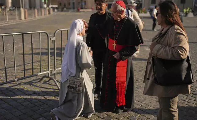Cardinal Silvano Tomasi blesses a nun in St. Peter's Square at the Vatican, Tuesday, April 22, 2025. (AP Photo/Francisco Seco)