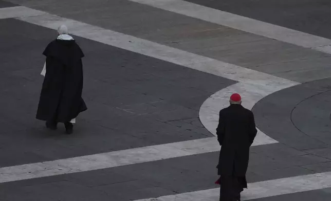 Cardinal Mauro Gambetti, right, walks away after leading a rosary prayer for the late Pope Francis, in St. Peter's Square at the Vatican, Monday April 21, 2025. (AP Photo/Andrew Medichini)