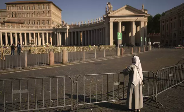 A nun leans on railings in St. Peter's Square at the Vatican,Tuesday, April 22, 2025. (AP Photo/Francisco Seco)