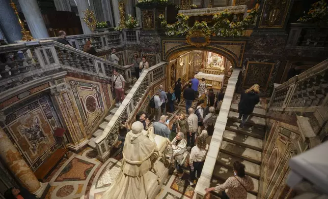Faithful and nuns gather by the statue of Pope Pius IX, inside in St. Mary Major basilica, where Pope Francis will be buried, in Rome, Tuesday, April 22, 2025. (AP Photo/Alessandra Tarantino)