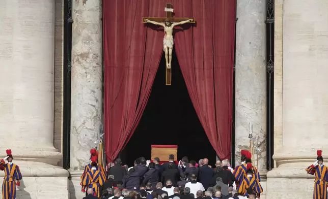 The body of Pope Francis is carried into St. Peter's Basilica at the Vatican, Wednesday, April 23, 2025, where he will lie in state for three days. (AP Photo/Stefano Costantino)