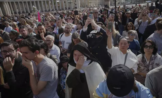 A nun cries as the body of Pope Francis is carried into St. Peter's Basilica at the Vatican, Wednesday, April 23, 2025, where he will lie in state for three days. (AP Photo/Emilio Morenatti)