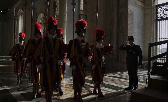 Vatican Swiss Guards march in the atrium of St. Peter's Basilica at the Vatican before the body of Pope Francis will be carried inside where he will lie in state for three days, Wednesday, April 23, 2025. (AP Photo/Andrew Medichini, Pool)