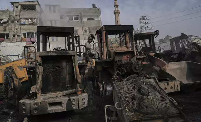 Palestinians examine the remains of bulldozers hit by an Israeli army airstrike in Jabaliya, northern Gaza Strip, on Tuesday, April 22, 2025. (AP Photo/Jehad Alshrafi)