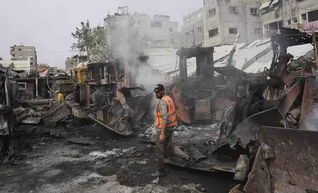 Palestinians examine the remains of bulldozers hit by an Israeli army airstrike in Jabaliya, northern Gaza Strip, on Tuesday, April 22, 2025. (AP Photo/Jehad Alshrafi)