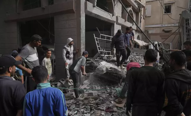 Palestinians inspect the damage caused by an Israeli army airstrike in Khan Younis, Gaza Strip, Tuesday, April 22, 2025. (AP Photo/Abdel Kareem Hana)