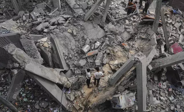 Palestinians inspect the damage caused by an Israeli army airstrike in Khan Younis, Gaza Strip, Tuesday, April 22, 2025. (AP Photo/Abdel Kareem Hana)