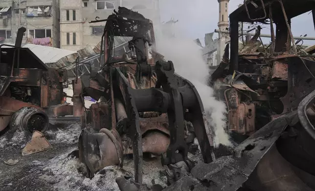 Smoke rises from the remains of bulldozers hit by an Israeli army airstrike in Jabaliya, northern Gaza Strip, on Tuesday, April 22, 2025. (AP Photo/Jehad Alshrafi)