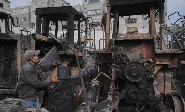 A Palestinian man extinguishes the fire from bulldozers after they were hit by an Israeli army airstrike in Jabaliya, northern Gaza Strip, on Tuesday, April 22, 2025. (AP Photo/Jehad Alshrafi)