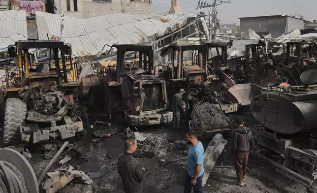 Palestinians examine the remains of bulldozers hit by an Israeli army airstrike in Jabaliya, northern Gaza Strip, on Tuesday, April 22, 2025. (AP Photo/Jehad Alshrafi)
