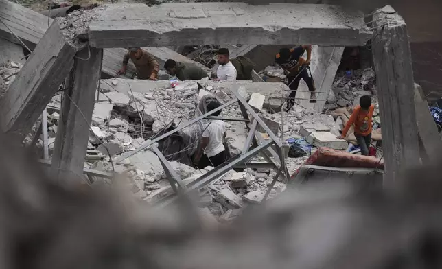 Palestinians inspect the damage caused by an Israeli army airstrike in Khan Younis, Gaza Strip, Tuesday, April 22, 2025. (AP Photo/Abdel Kareem Hana)