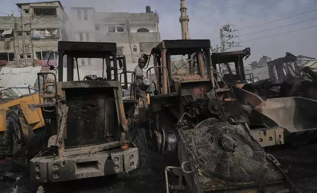 Palestinians examine the remains of bulldozers hit by an Israeli army airstrike in Jabaliya, northern Gaza Strip, on Tuesday, April 22, 2025. (AP Photo/Jehad Alshrafi)