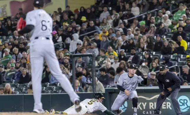 Chicago White Sox first base Andrew Vaughn (25) attempts to tag out Athletics' Jacob Wilson (5) during the eighth inning of a baseball game Friday, April 25, 2025, in West Sacramento, Calif. (AP Photo/Sara Nevis)