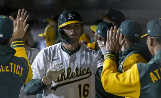 Athletics' Nick Kurtz (16) celebrates in the dugout after scoring during the seventh inning of a baseball game against the Chicago White Sox Friday, April 25, 2025, in West Sacramento, Calif. (AP Photo/Sara Nevis)