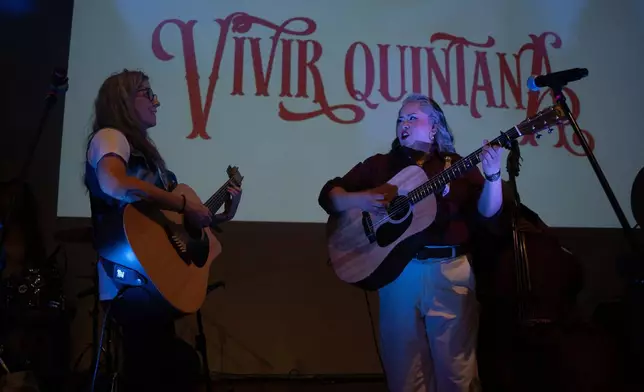 Mexican corridos singer Vivir Quintana, right, performs her new album, about violence against women, in Mexico City, Thursday, April 24, 2025. (AP Photo/Aurea Del Rosario)