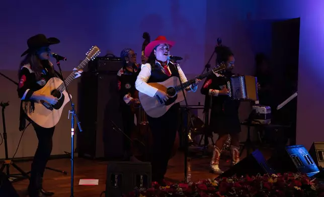 Mexican corridos singer Vivir Quintana, center, performs her new album, about violence against women, in Mexico City, Thursday, April 24, 2025. (AP Photo/Aurea Del Rosario)