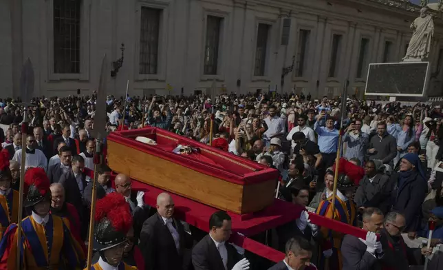 The body of Pope Francis is carried into St. Peter's Basilica at the Vatican, Wednesday, April 23, 2025, where he will lie in state for three days. (AP Photo/Emilio Morenatti)
