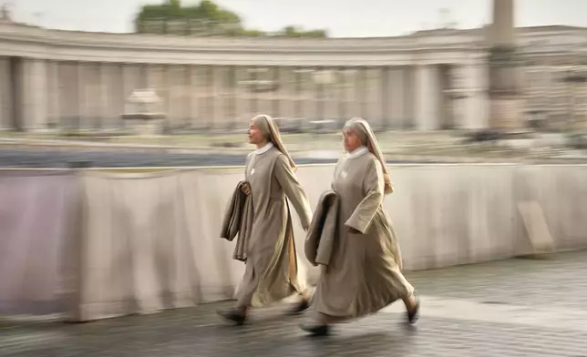 Nuns arrive in St. Peter's Square as they await the arrival of the body of Pope Francis, who will lie in state at St. Peter's Basilica for three days, at the Vatican, Wednesday, April 23, 2025. (AP Photo/Andreea Alexandru)