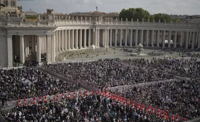 People gather in St. Peter's Square as they await the arrival of the body of Pope Francis, who will lie in state at St. Peter's Basilica for three days, at the Vatican, Wednesday, April 23, 2025. (AP Photo/Markus Schreiber)