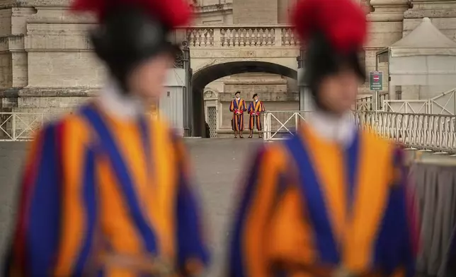 Pontifical Swiss guards stand in St. Peter's Square before the arrival of the body of Pope Francis, who will lie in state at St. Peter's Basilica for three days, at the Vatican, Wednesday, April 23, 2025. (AP Photo/Andreea Alexandru)
