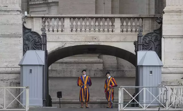 Vatican Swiss Guards stand at the Arch of the Bells where the body of Pope Francis will be carried on its way to St. Peter's Basilica, where it will lie in state for three days, at the Vatican, Wednesday, April 23, 2025. (AP Photo/Andrew Medichini)