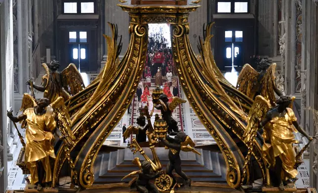 Gianlorenzo Bernini's monumental canopy serves as a dramatic frame as Cardinal Camerlengo Kevin Joseph Farrell leads the procession accompanying Pope Francis's body into St. Peter's Basilica at the Vatican on Wednesday, April 23, 2025. The Pope will lie in state for three days. (Vatican Media via AP)
