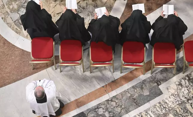 Nuns pray in front of the body of Pope Francis inside St. Peter's Basilica at the Vatican, Wednesday, April 23, 2025, where he will lie in state for three days. (Alessandro Di Meo/Pool Photo via AP)