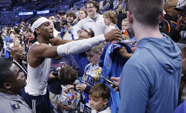 Oklahoma City Thunder guard Shai Gilgeous-Alexander, left, signs autographs for fans before Game 1 of an NBA first-round playoff series against the Memphis Grizzles, Sunday, April 20, 2025, in Oklahoma City. (AP Photo/Nate Billings)
