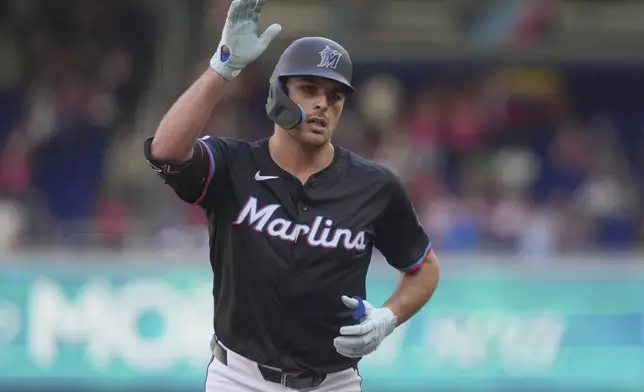 Miami Marlins' Matt Mervis gestures to the team after hitting a home run during the second inning of a baseball game against the Washington Nationals, Saturday, April 12, 2025, in Miami. (AP Photo/Marta Lavandier)