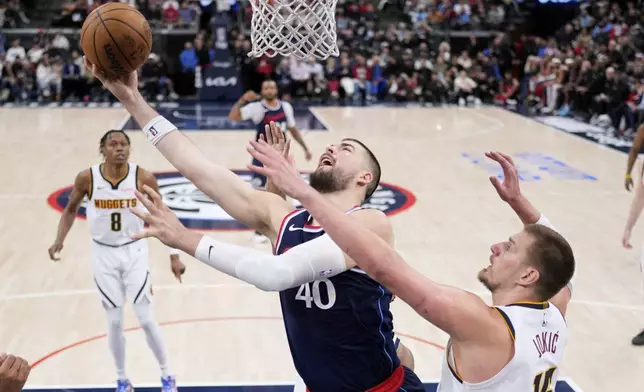 Los Angeles Clippers center Ivica Zubac, center, shoots as Denver Nuggets center Nikola Jokic defends during the second half in Game 4 of an NBA basketball first-round playoff series Saturday, April 26, 2025, in Inglewood, Calif. (AP Photo/Mark J. Terrill)