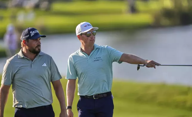 Ben Griffin, right, walks up the 17th fairway with teammate Andrew Novak during the final round of the PGA Zurich Classic golf tournament at TPC Louisiana in Avondale, La., Sunday, April 27, 2025. (AP Photo/Gerald Herbert)