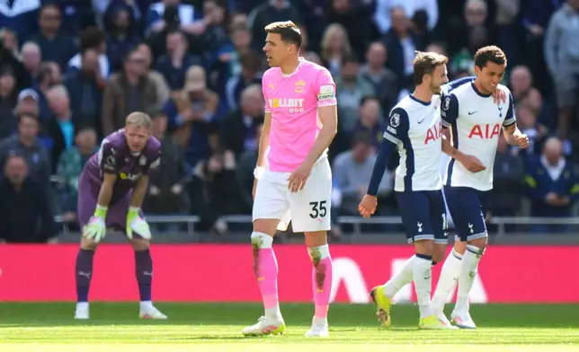 Southampton goalkeeper Aaron Ramsdale, background left and Jan Bednarek foreground react after Tottenham Hotspur's Brennan Johnson, right, scored his side's second goal of the game as he celebrates with teammate James Maddison, during the English Premier League soccer match between Tottenham Hotspur and Southampton at Tottenham Hotspur Stadium, in London, Sunday April 6, 2025. (Bradley Collyer/PA via AP)