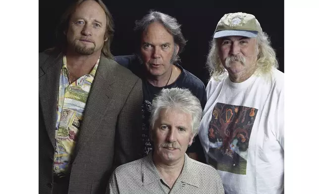 FILE - Musicians Stephen Stills, left, Neil Young, background center, Graham Nash, seated, and David Crosby pose for a photo at the Pierre Hotel, Oct. 13, 1999, in New York. (AP Photo/Jim Cooper, File)