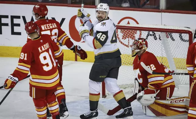 Vegas Golden Knights' Tomas Hertl (48) celebrates his team's goal as Calgary Flames goalie Dustin Wolf (32) reacts during the first period of an NHL hockey game in Calgary, Alberta, Tuesday, April 15, 2025. (Jeff McIntosh/The Canadian Press via AP)