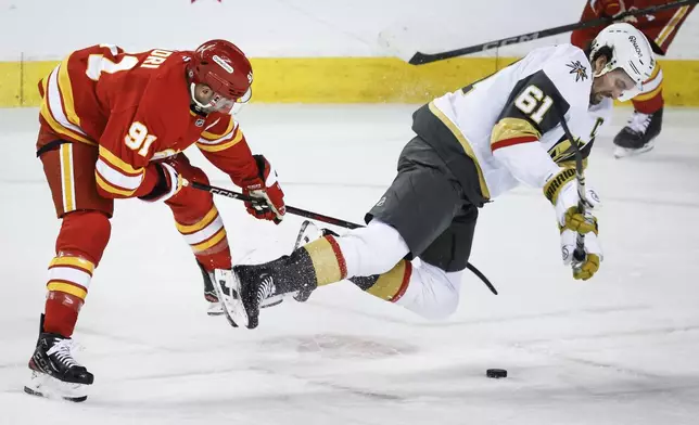 Vegas Golden Knights' Mark Stone, right, is tripped by Calgary Flames' Nazem Kadri during first period NHL hockey action in Calgary on Saturday, April 5, 2025. (Jeff McIntosh/The Canadian Press via AP)