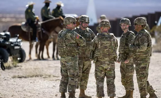 FILE - Army soldiers chat while waiting the arrival of Defense Secretary Pete Hegseth to the US-Mexico border in Sunland Park, N.M., Monday, Feb. 3, 2025. (AP Photo/Andres Leighton, File)