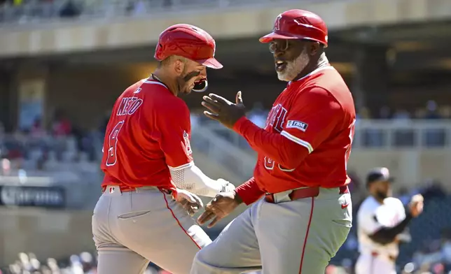 Los Angeles Angels' Zachary Neto, left, celebrates with third base coach Eric Young Sr., after hitting a home run off of Minnesota Twins pitcher Simeon Woods Richardson during the third inning of a baseball game, Saturday, April 26, 2025, in Minneapolis. (AP Photo/Craig Lassig)